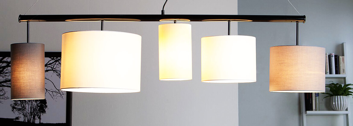 Hanglamp met verschillende lampenkappen boven de eettafel