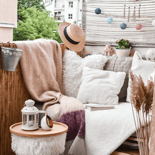 Kussens, bloemen en dekens voor het balkon